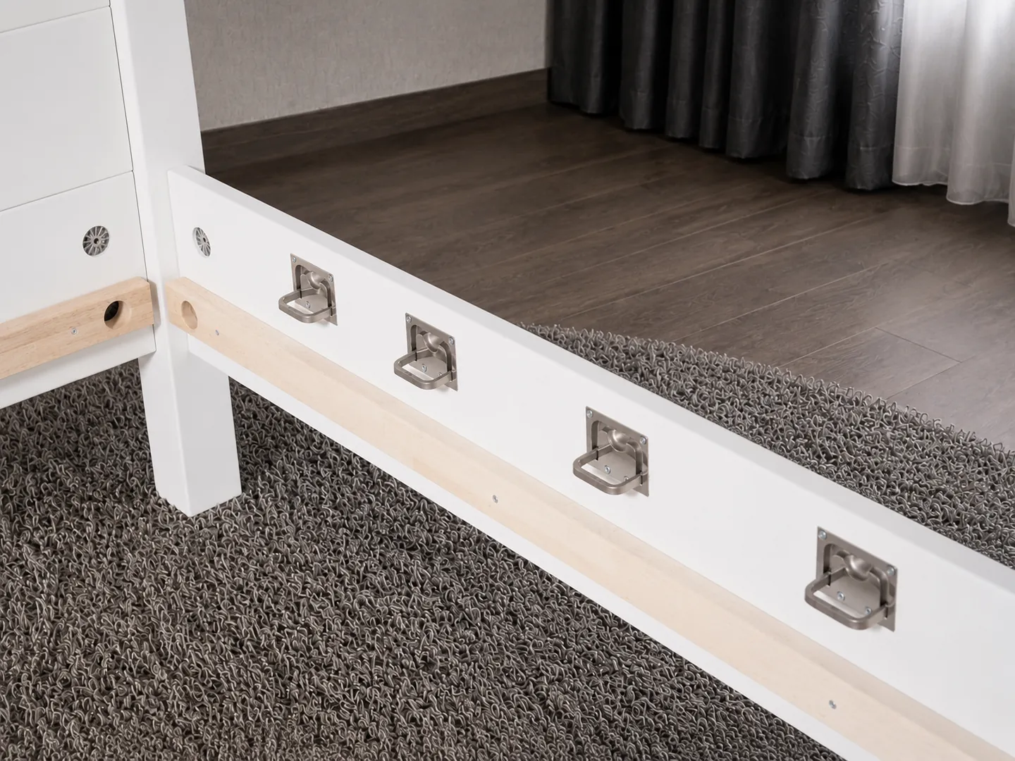 Detailaufnahme der Befestigungsösen aus Edelstahl am BOMINA Bett Modell Weiß